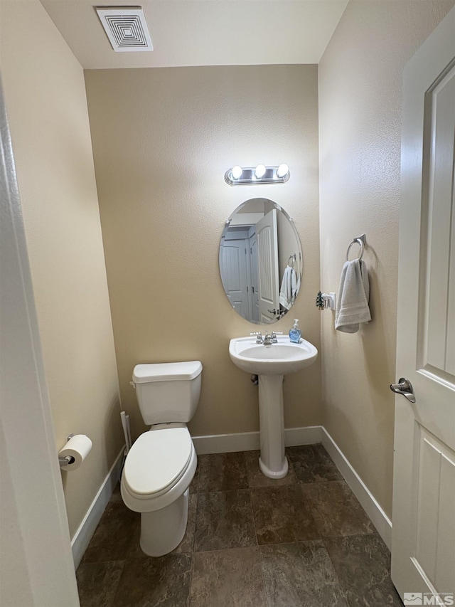 5282 Western Way, Winnemucca, NV 89445 - half bath with toilet, baseboards, and stone finish flooring