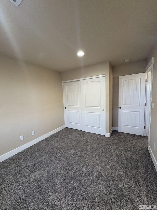 5282 Western Way, Winnemucca, NV 89445 - unfurnished bedroom featuring dark carpet, baseboards, recessed lighting, and a closet