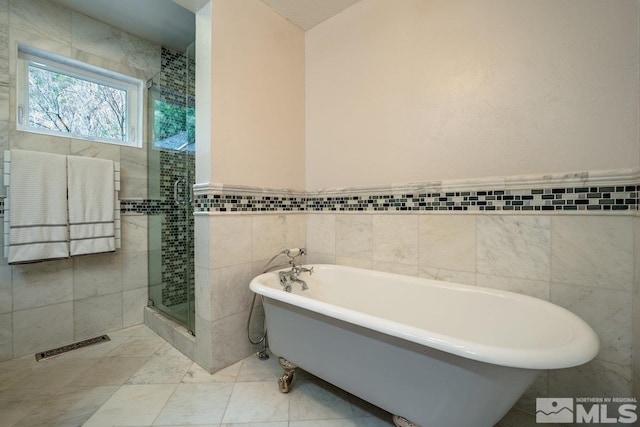 182 Mill St, Genoa, NV 89411 - bathroom featuring tile walls, a shower stall, a freestanding tub, and wainscoting