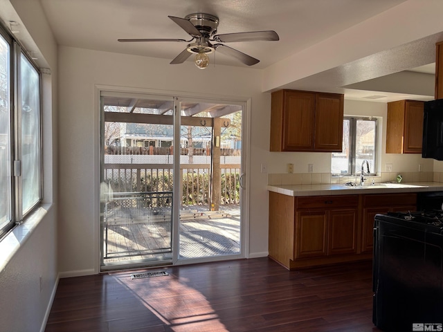 1721 Burnside Dr, Sparks, NV 89434 - kitchen with tile counters, black gas range, dark wood-type flooring, and a sink