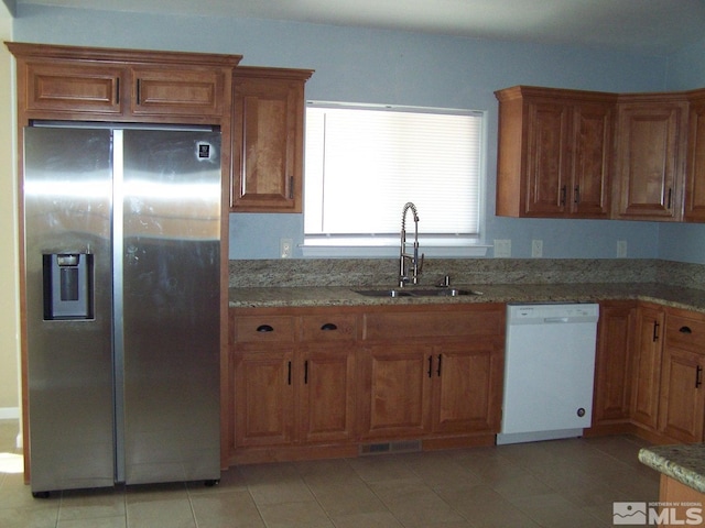 742 Megan Way, Fallon, NV 89406 - kitchen with stainless steel refrigerator with ice dispenser, white dishwasher, a sink, and brown cabinets
