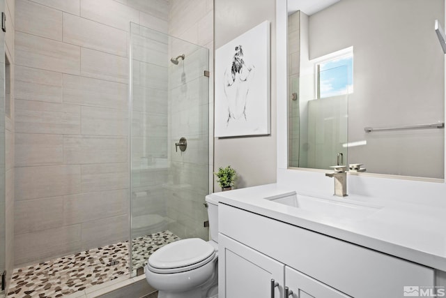 bathroom featuring a stall shower, toilet, and vanity