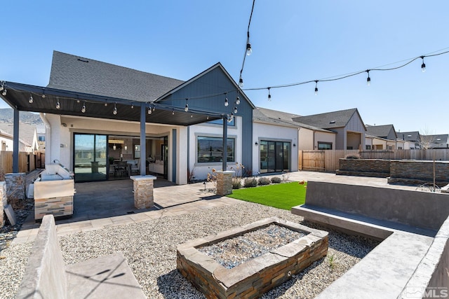 rear view of house featuring an outdoor fire pit, a patio, a fenced backyard, and stucco siding