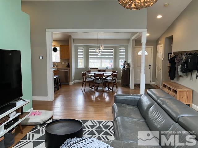 living area featuring wood finished floors, recessed lighting, baseboards, and a chandelier