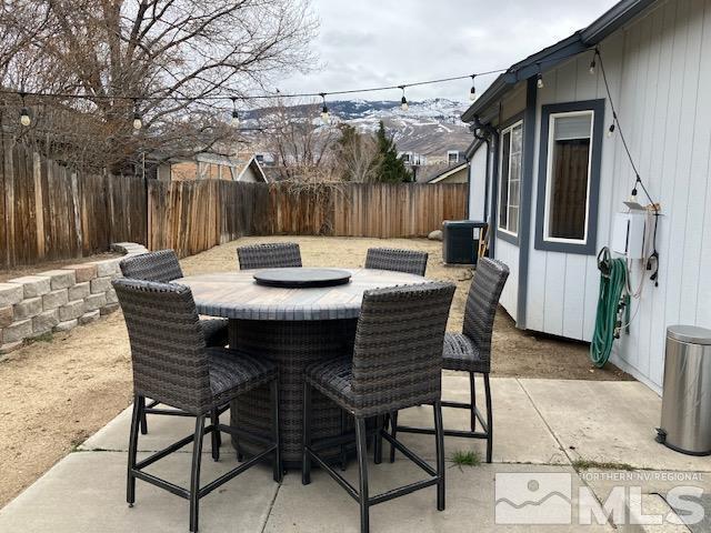 view of patio / terrace featuring a fenced backyard, outdoor dining area, cooling unit, and a mountain view