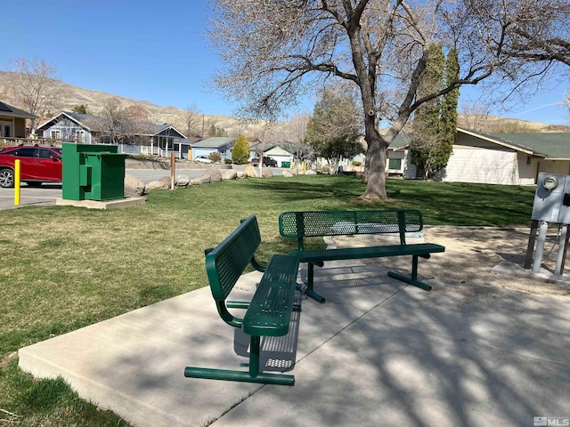 view of community featuring a mountain view, a yard, and a residential view