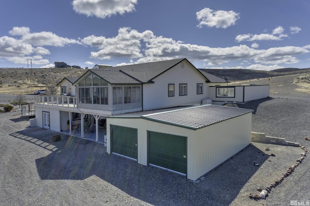 1875 View Ct, Fernley, NV 89408 - rear view of house with a sunroom, a patio, a garage, and a mountain view