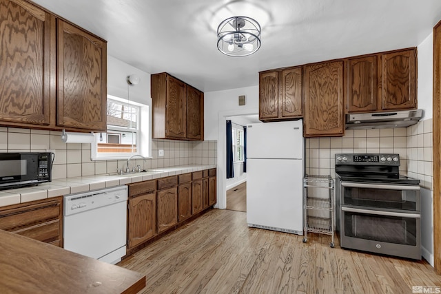 435 14th St, Sparks, NV 89431 - kitchen with white appliances, under cabinet range hood, a sink, and decorative backsplash