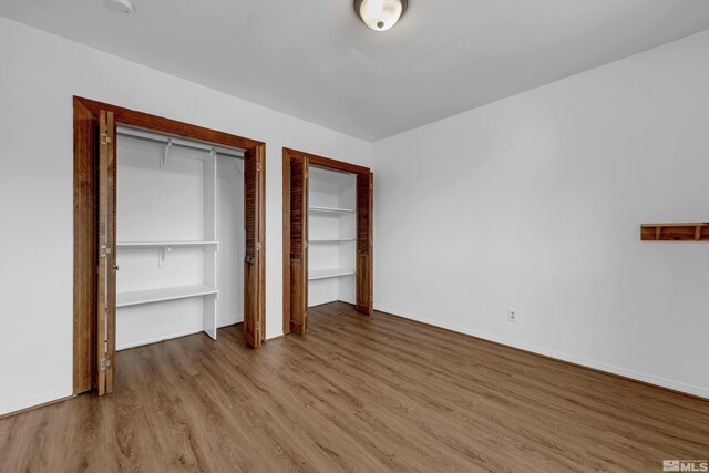 435 14th St, Sparks, NV 89431 - unfurnished bedroom with multiple closets, wood finished floors, and baseboards