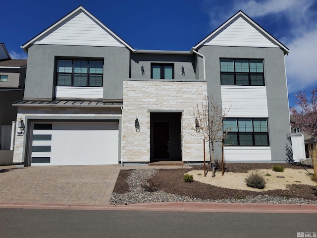 5449 Side Saddle Trl, Reno, NV 89511 - view of front of property featuring stone siding, a garage, stucco siding, a standing seam roof, and decorative driveway