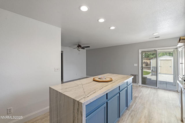 7721 Welsh Dr, Reno, NV 89506 - kitchen featuring blue cabinetry, light wood-style floors, recessed lighting, a ceiling fan, and a center island