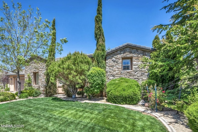 10100 Via Ponte, Reno, NV 89511 - view of property hidden behind natural elements with stone siding and a front lawn