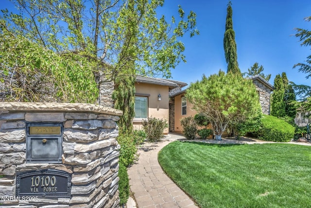10100 Via Ponte, Reno, NV 89511 - obstructed view of property with stone siding, stucco siding, and a front lawn