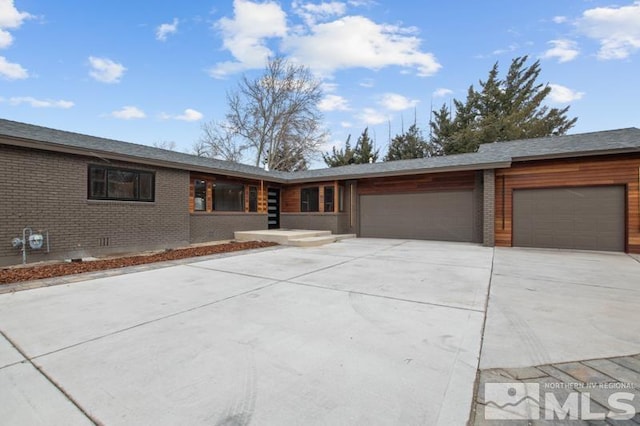 995 Skyline Blvd, Reno, NV 89509 - view of front of house with an attached garage, brick siding, and concrete driveway