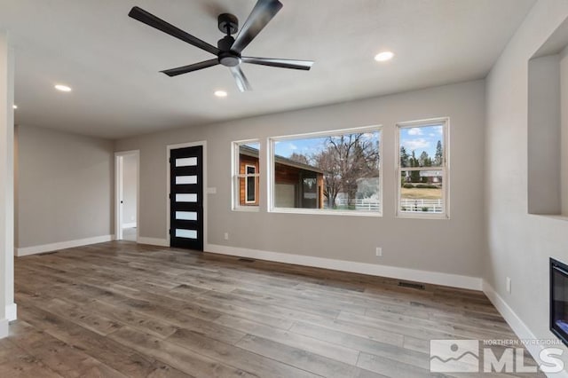 995 Skyline Blvd, Reno, NV 89509 - unfurnished living room featuring wood finished floors, recessed lighting, baseboards, ceiling fan, and a glass covered fireplace