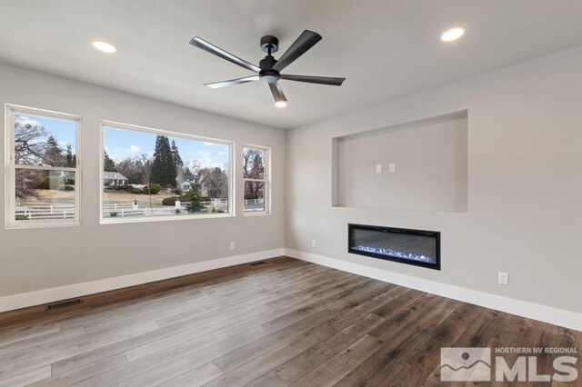 995 Skyline Blvd, Reno, NV 89509 - unfurnished living room with ceiling fan, wood finished floors, a glass covered fireplace, baseboards, and recessed lighting