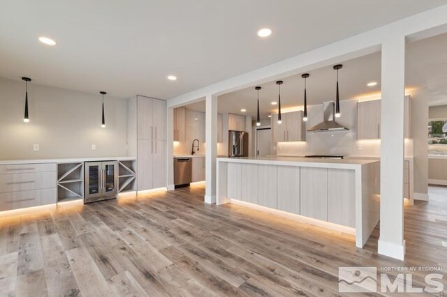 995 Skyline Blvd, Reno, NV 89509 - kitchen with stainless steel appliances, modern cabinets, wine cooler, wall chimney range hood, and light wood-style flooring