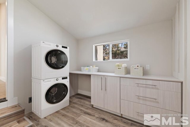 995 Skyline Blvd, Reno, NV 89509 - laundry room with stacked washer and clothes dryer, light wood-type flooring, and cabinet space