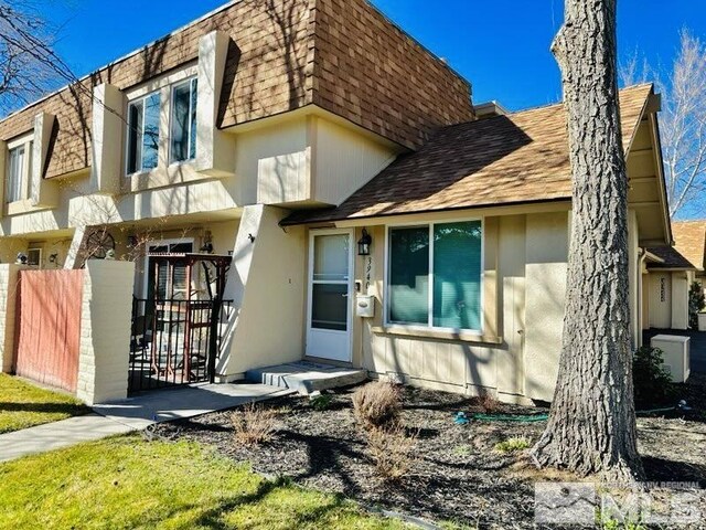 3940 Pheasant, Carson City, NV 89701 - view of front of house featuring roof with shingles, mansard roof, fence, and stucco siding