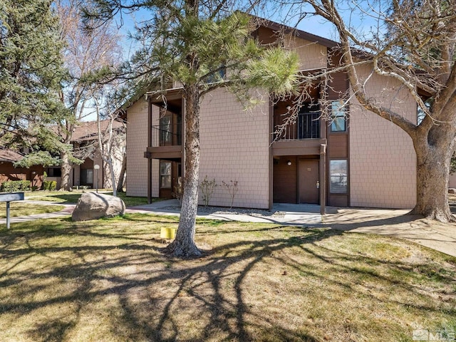 1465 E Peckham Ln Apt 55, Reno, NV 89502 - back of property with a balcony and a lawn