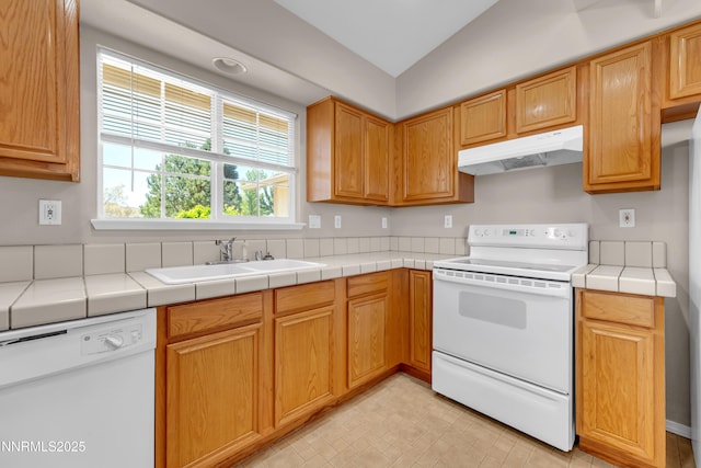 2172 Redhead Dr, Sparks, NV 89441 - kitchen featuring white appliances, under cabinet range hood, a sink, vaulted ceiling, and tile counters