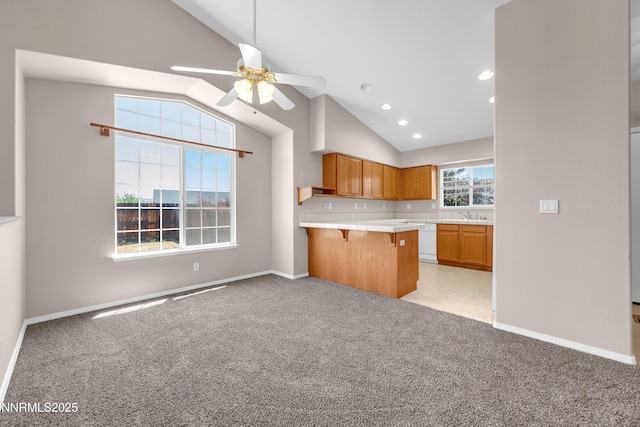 2172 Redhead Dr, Sparks, NV 89441 - kitchen featuring dishwasher, a ceiling fan, a breakfast bar area, light countertops, and light colored carpet