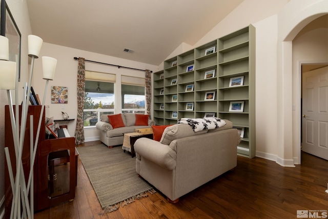 1659 Chiquita Ci, Minden, NV 89423 - living room featuring lofted ceiling, dark wood-type flooring, arched walkways, and baseboards