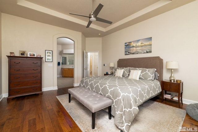 1659 Chiquita Ci, Minden, NV 89423 - bedroom featuring dark wood-type flooring, a raised ceiling, arched walkways, baseboards, and ensuite bath