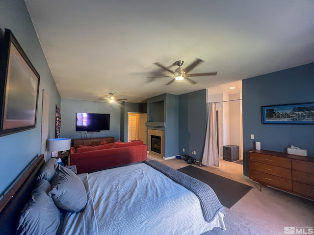 1090 Aster Ln, Fernley, NV 89408 - bedroom with carpet floors, a ceiling fan, a glass covered fireplace, and connected bathroom