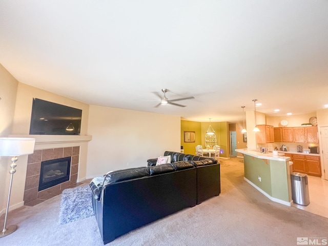 1090 Aster Ln, Fernley, NV 89408 - living room featuring light carpet, a tiled fireplace, ceiling fan, and baseboards