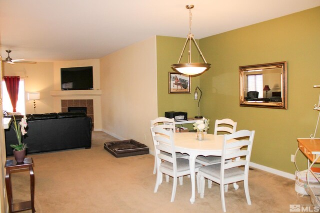1090 Aster Ln, Fernley, NV 89408 - dining space featuring carpet floors, ceiling fan, a tiled fireplace, and baseboards