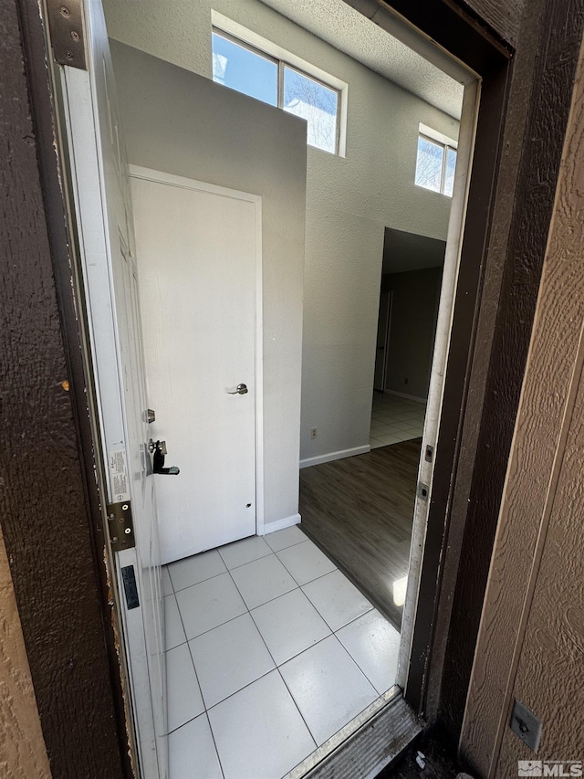 2375 Tripp Dr Unit 6, Reno, NV 89512 - hallway featuring tile patterned flooring, a textured wall, healthy amount of natural light, and baseboards