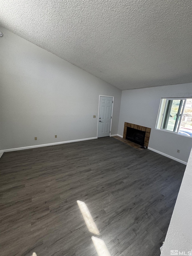 2375 Tripp Dr Unit 6, Reno, NV 89512 - unfurnished living room with a textured ceiling, a fireplace, dark wood-type flooring, baseboards, and lofted ceiling