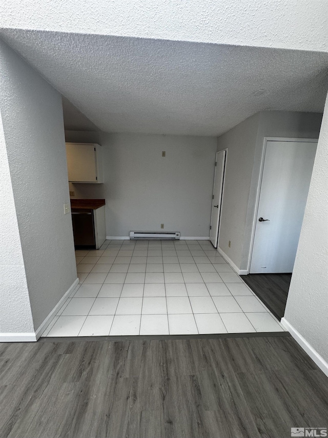 2375 Tripp Dr Unit 6, Reno, NV 89512 - unfurnished living room with baseboard heating, light wood-type flooring, a textured ceiling, and baseboards