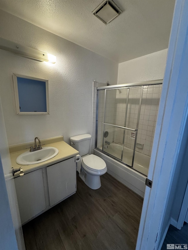 2375 Tripp Dr Unit 6, Reno, NV 89512 - bathroom with wood finished floors, a textured wall, a textured ceiling, vanity, and bath / shower combo with glass door