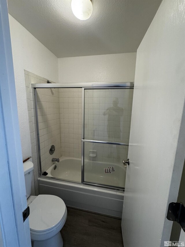 2375 Tripp Dr Unit 6, Reno, NV 89512 - bathroom featuring wood finished floors, toilet, enclosed tub / shower combo, a textured ceiling, and a textured wall