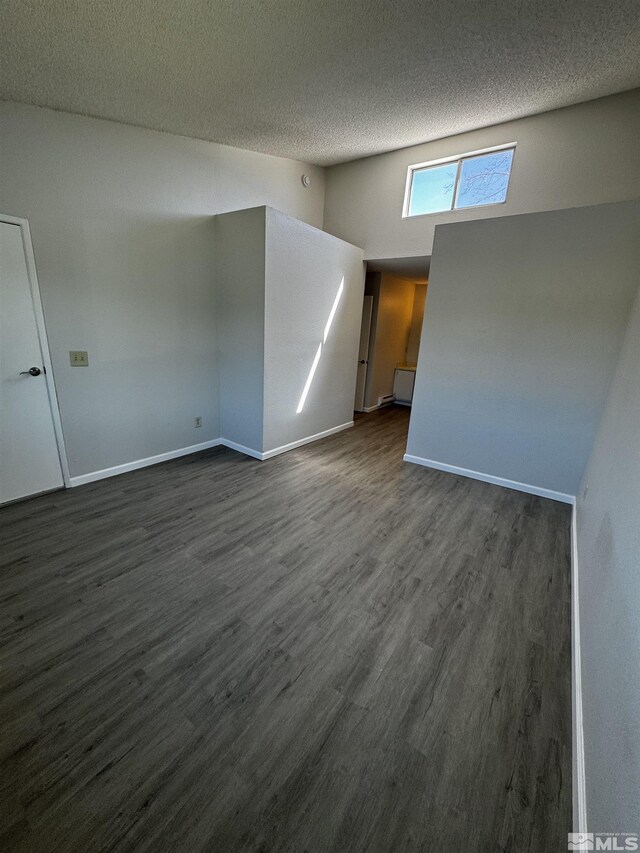 2375 Tripp Dr Unit 6, Reno, NV 89512 - unfurnished living room featuring dark wood finished floors, baseboards, high vaulted ceiling, and a textured ceiling