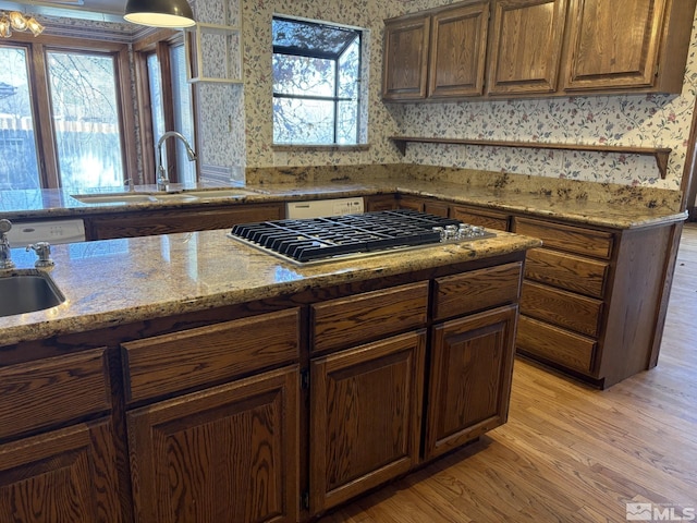 3 Comstock Cir, Carson City, NV 89703 - kitchen featuring stainless steel gas cooktop, a sink, light wood-style flooring, light stone countertops, and wallpapered walls