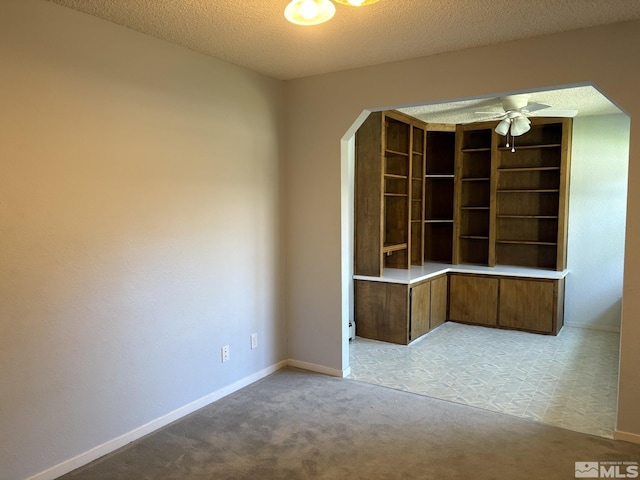 3 Comstock Cir, Carson City, NV 89703 - unfurnished room featuring light colored carpet, a ceiling fan, baseboards, a textured ceiling, and arched walkways