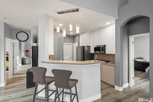 17000 Wedge Pkwy Unit 3221, Reno, NV 89511 - kitchen with appliances with stainless steel finishes, modern cabinets, light wood finished floors, a kitchen bar, and recessed lighting