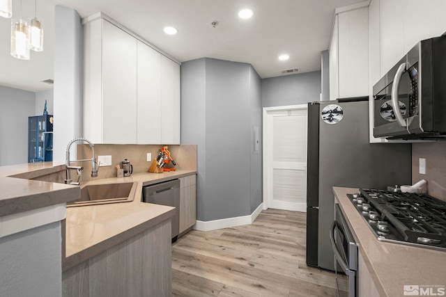 17000 Wedge Pkwy Unit 3221, Reno, NV 89511 - kitchen with appliances with stainless steel finishes, modern cabinets, light wood-style flooring, white cabinetry, and baseboards