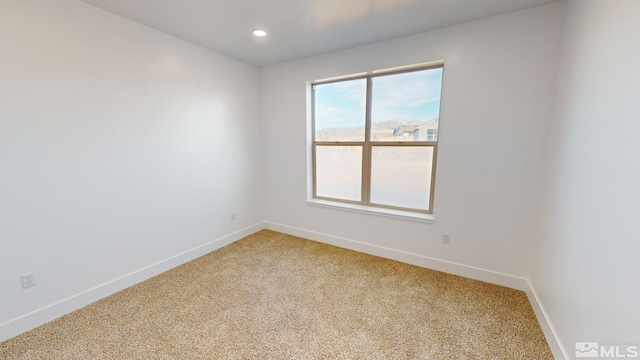 spare room with light colored carpet, baseboards, and recessed lighting