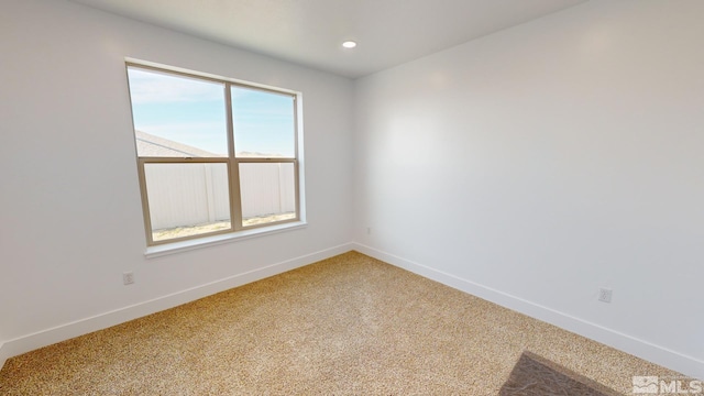 empty room featuring light carpet, baseboards, and recessed lighting