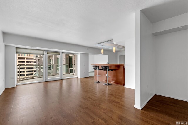 255 N Sierra St Unit 815, Reno, NV 89501 - unfurnished living room featuring a dry bar, wood finished floors, and baseboards