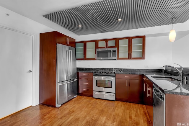 255 N Sierra St Unit 815, Reno, NV 89501 - kitchen featuring appliances with stainless steel finishes, a sink, light wood-style flooring, and dark stone countertops