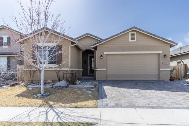 7117 Mustengo Dr, Reno, NV 89506 - ranch-style house with an attached garage, stucco siding, decorative driveway, fence, and a tiled roof