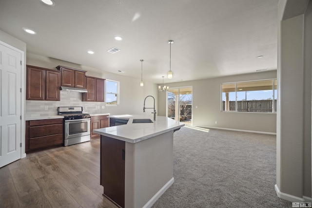 7117 Mustengo Dr, Reno, NV 89506 - kitchen featuring stainless steel gas stove, a sink, light countertops, baseboards, and healthy amount of natural light