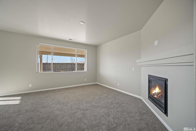 7117 Mustengo Dr, Reno, NV 89506 - unfurnished living room featuring a glass covered fireplace, carpet, and baseboards