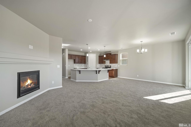 7117 Mustengo Dr, Reno, NV 89506 - unfurnished living room with a chandelier, carpet flooring, recessed lighting, baseboards, and a glass covered fireplace