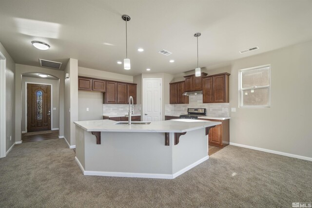 7117 Mustengo Dr, Reno, NV 89506 - kitchen featuring stainless steel range oven, a sink, light colored carpet, backsplash, and light countertops
